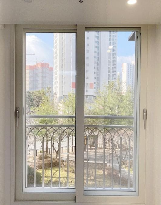 교체한 흰색 창틀과 양쪽 손잡이가 달린 창짝